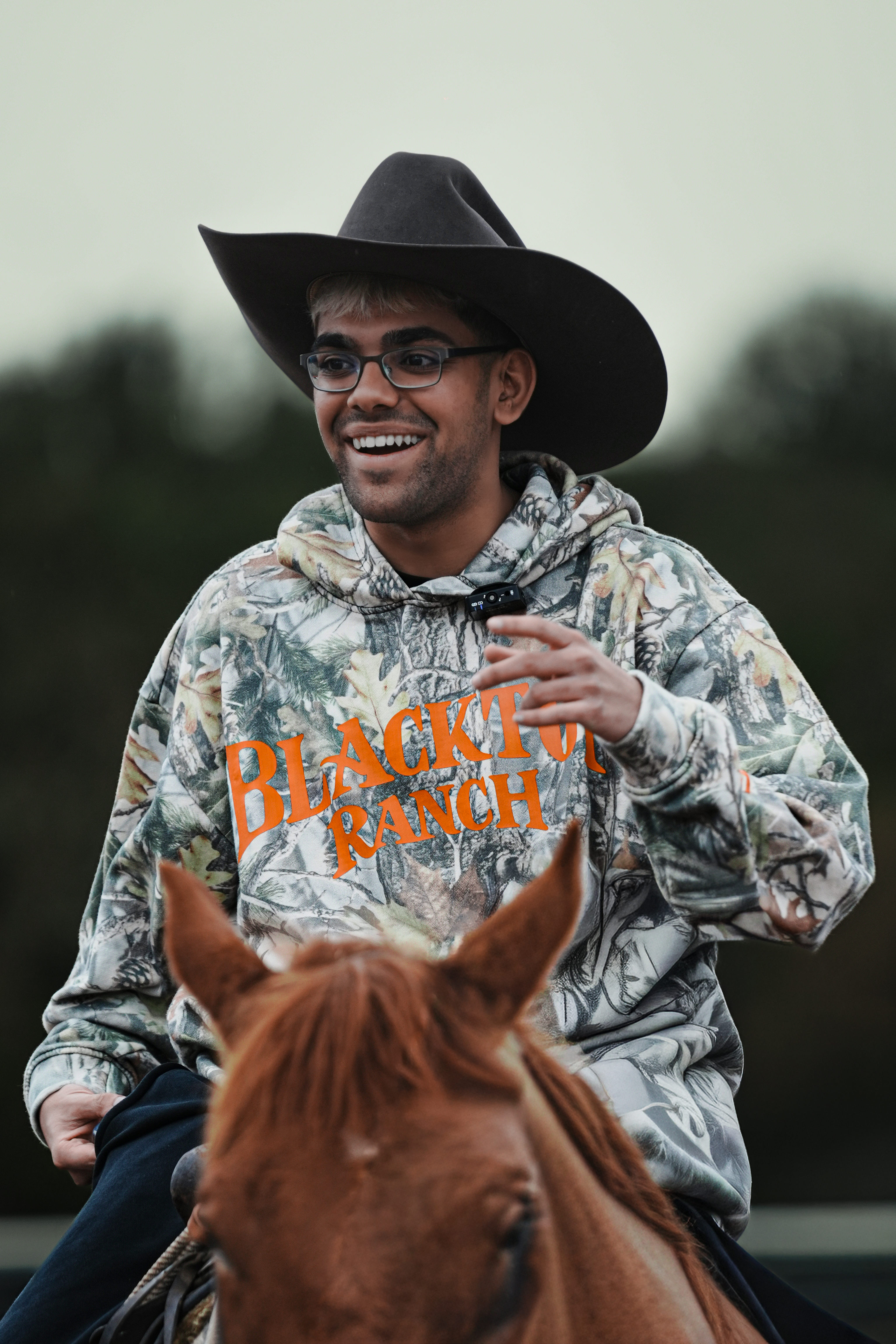 Blacktop Ranch hoodie worn by Neon featuring forest camouflage oversized fit