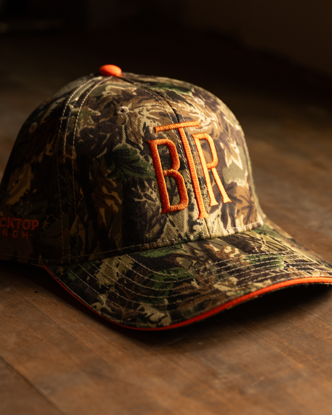 Angled view of Blacktop Ranch camo cap showing brim shape