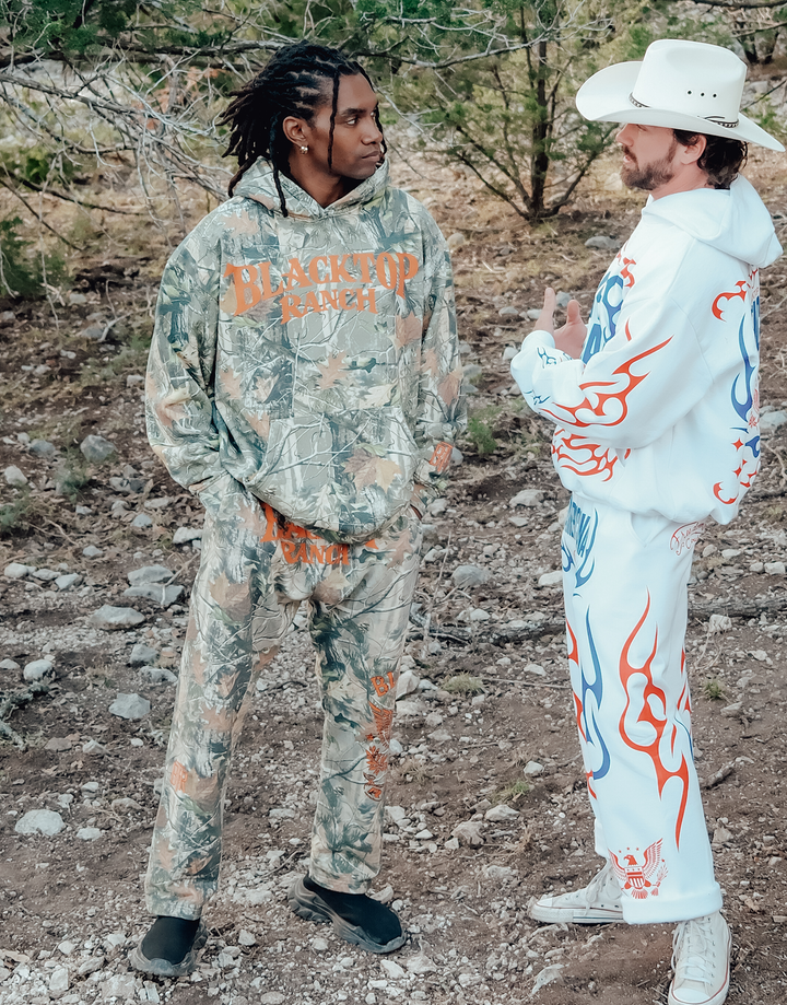 Lifestyle shot of Blacktop Ranch camo hoodie oversized fit in outdoor setting