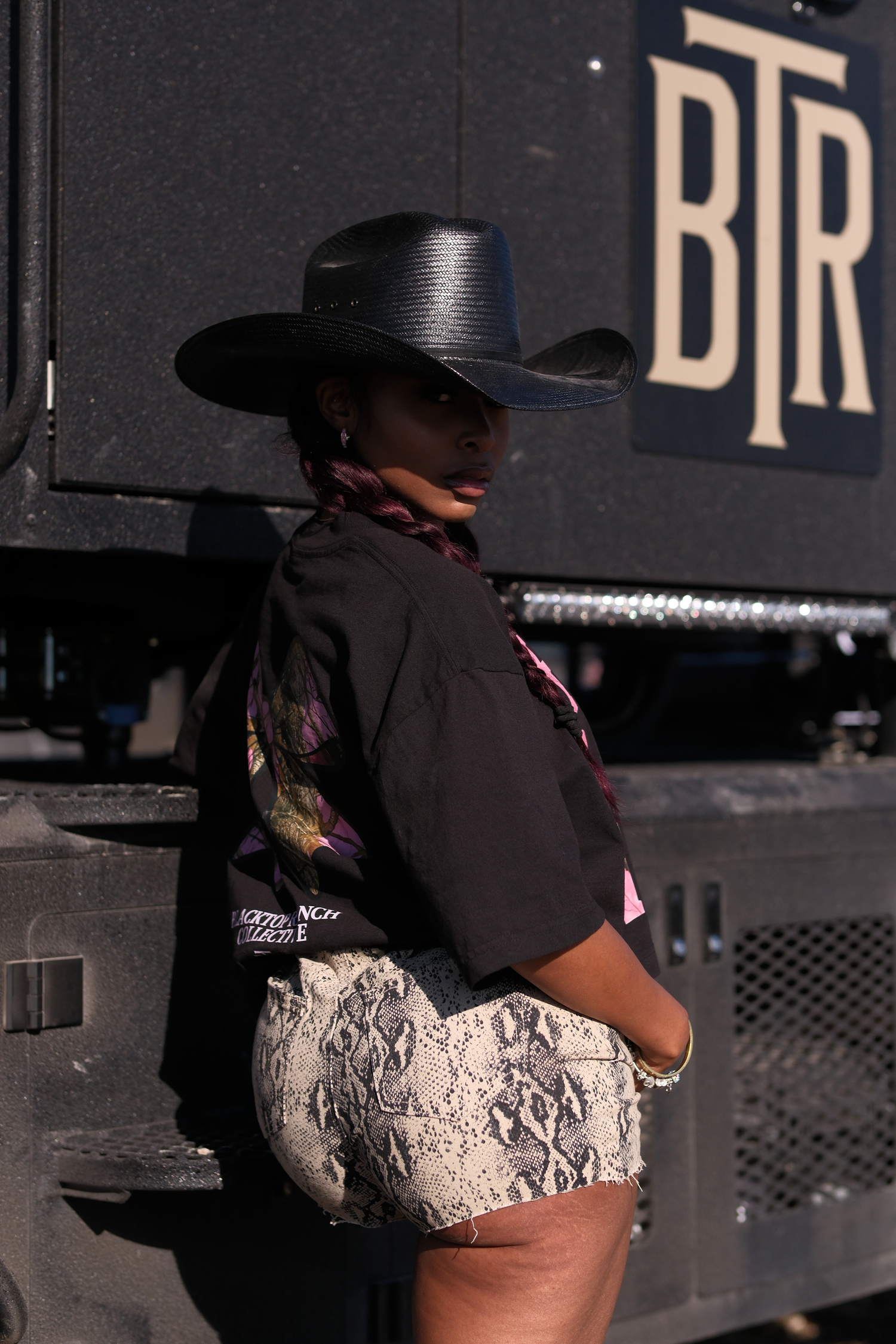 Side profile of cropped graphic tee by Blacktop Ranch relaxed fit style with cowboy hat